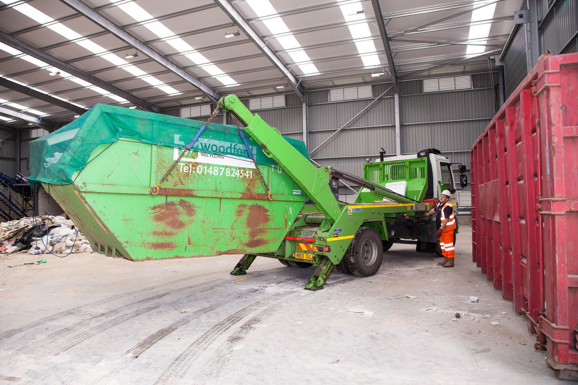 green skip being unloaded at Woodford Recycling